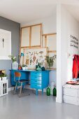 Blue-painted desk and retro chair in niche