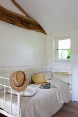 Antique, white bed in renovated attic bedroom