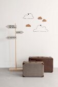 Playroom decorations; suitcases, signpost and hand-crafted clouds made from wire and cardboard on wall