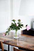 Pink peonies in glass vase on wooden table