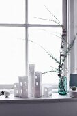 DIY-Papierhäuser als Windlicht auf weihnachtlich dekorierter Fensterbank