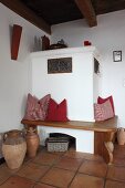 Comfortable bench with scatter cushions around masonry corner stove