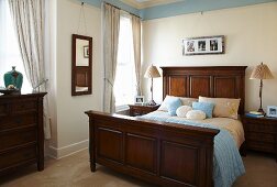 Traditional bedroom with accessories and pale blue frieze combined with dark wooden furniture