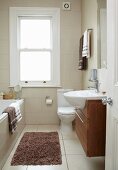 Narrow, traditional bathroom in renovated period building; modern washstand with sink protruding over floating base unit