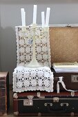 Open, vintage suitcase, candelabra and white crocheted doily