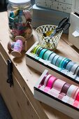 DIY dispenser for various washi tapes and sewing utensils on top of wooden trunk