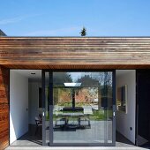 Point 7, Winchester, United Kingdom. Architect: Dan Brill Architects, 2014. View from terrace through sliding doors into interior of contemporary house
