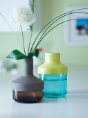 Coloured glass vases with different plastic lids