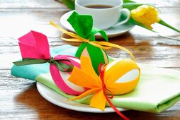 Easter decorations - eggs decorated with strips of colourful felt and linen napkin on plate