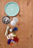Materials for crafting wall decoration; old colander, colourful yarn, candle holder, glue