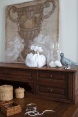 Jewellery, storage baskets and canvas with urn motif on antique bureau