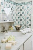Traditional, floral tiles behind washstand with classic marble top and old tap fitting