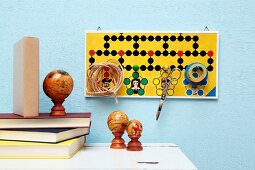 Creative pin board made from board game collage for storing scissors, sticky tape and twine