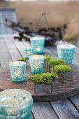 Moss in cutter with lanterns on a rustic wooden table