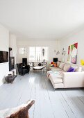 Moderne Sofakombination und schwarzer Ledersessel neben Couchtisch in Landhaus Wohnzimmer