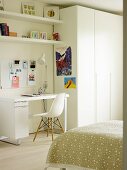 Desk and classic chair next to white wardrobe in teenager's bedroom