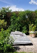 Idyllic seating area in garden with black and white striped futon sofa