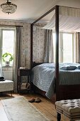 Canopy bed with dark wooden frame in rustic bedroom