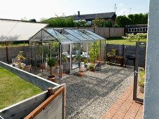 Cosily furnished retreat in greenhouse on gravel terrace in garden