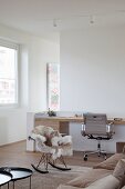 Custom, wooden modern desk, classic office chair, Eames rocking chair and fur blanket in comfortable lounge area