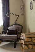 Armlehnsessel im Rokoko Stil und Stehleuchte in Zimmerecke, seitlich Brennholz an Wand
