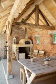 Rustic roofed terrace with exposed masonry and pizza oven on renovated farm