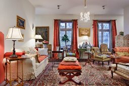 Interior filled with antique seating and side tables with mixture of patterns on Oriental rugs and traditional upholstery fabrics