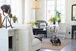 Retro ride-on car on rug and various black and white chairs in living area