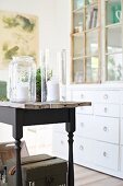 Tall glass candle lanterns on rustic table with black-painted frame