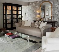Classic living room in shades of grey with plexiglas coffee table and black display cabinet