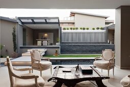 View from roofed lounge area to modern garden with pool