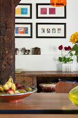 View past fruit bowl on dining table to gallery of modern pictures above rustic battered sideboard