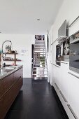 Metal staircase in designer kitchen with black, tiled floor