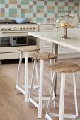 Bar stools with metal frames and wooden seats at breakfast bar in kitchen