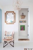 Chair with wooden frame and pink cover next to open door and view of wall with hanging basket bag