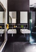 Zwei kantige Waschbecken in modernem Badezimmer, seitlich Spiegel mit Antikrahmen
