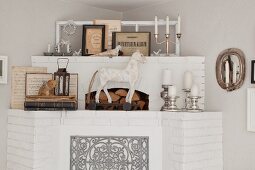 Whitewashed brick fireplace decorated with animal figurines and silver candlesticks