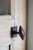 Antique iron door handle on stripped wooden door