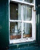 Blick in Fenster von altem Haus mit Teeservice