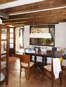 Traditioneller, spanischer Tisch und Holzstühle im Esszimmer mit Holzbalkendecke