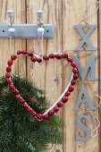 Weihnachtliche Wanddekoration mit Tannenzweigen,Herz aus Cranberries & Schriftzug XMAS