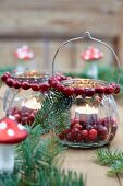 Glaswindlichthalter weihnachtlich dekoriert mit Cranberries & Tannenzweigen