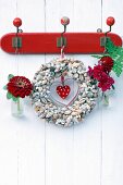 Wreath of seashells decorated with zinnia, dahlia and snap dragon hung on vintage coat rack