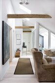 Wing-back armchairs with pale brown upholstery and rug in converted attic