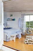 View from terrace into maritime-style bedroom in shades of blue