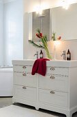 Adventlicher Amaryllisstrauss auf Waschtisch in weißem Bad
