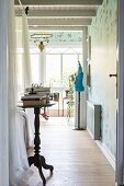 Vintage-style tall bistro table in bedroom; tailors' dummy in background