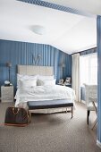 Elegant, vintage-style bedroom with blue and white striped wallpaper