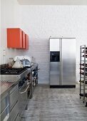 Stainless steel counter, red wall-mounted cabinets and fridge-freezer in kitchen area