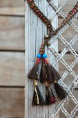 Ethnic tassels and weathered net attached to board